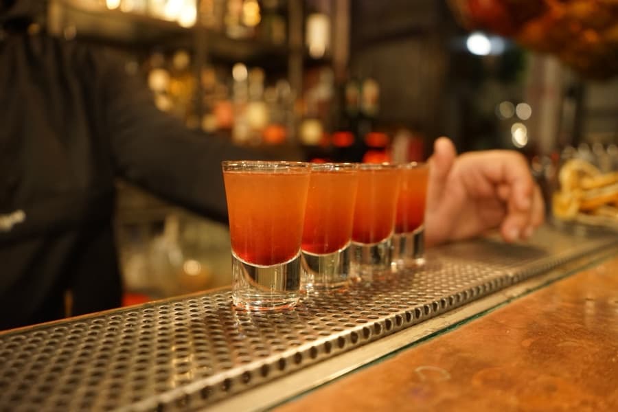 A row of layered shot drinks lined up on a bar
